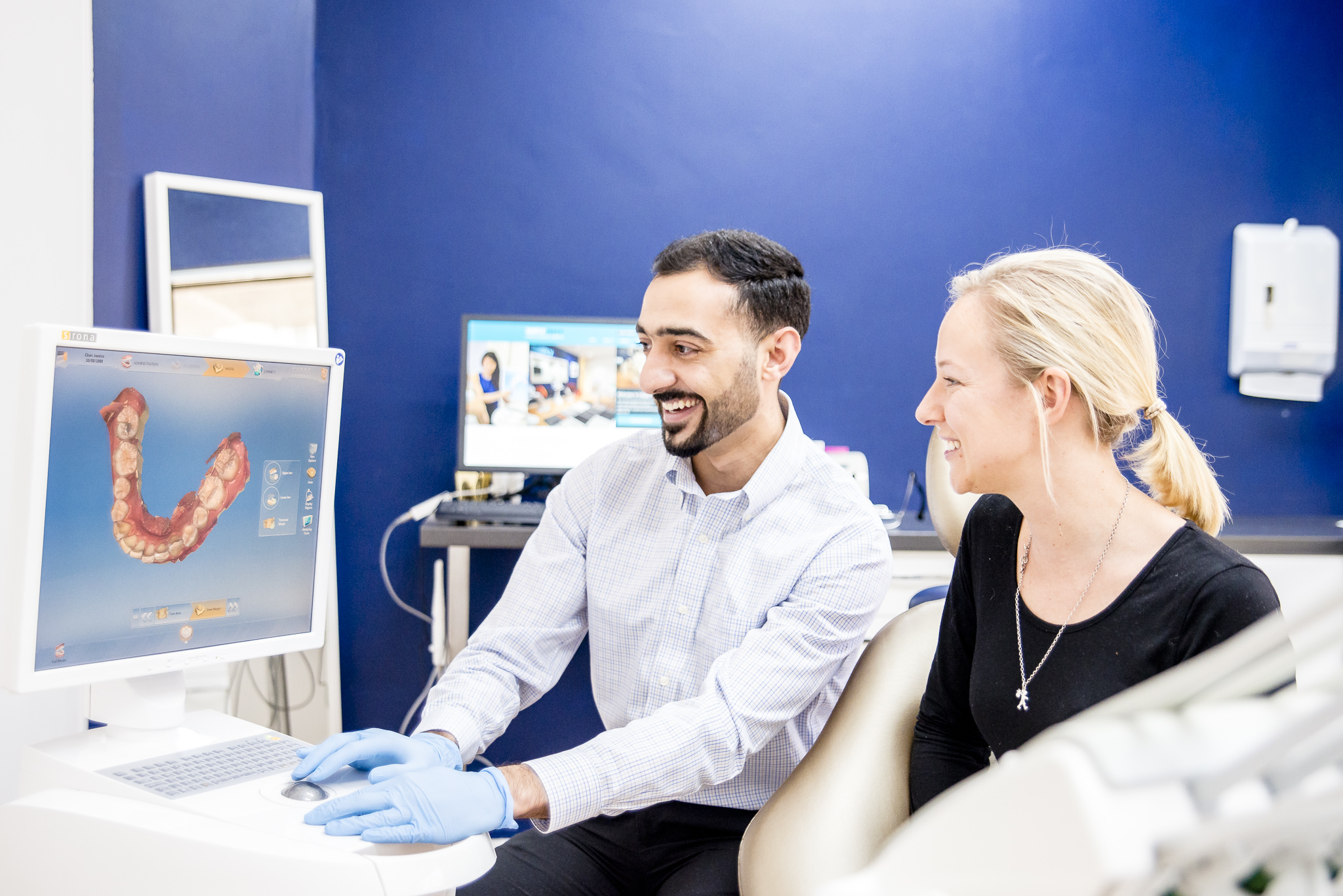 Dentist at Simply Teeth explaining tooth problem on a computer
